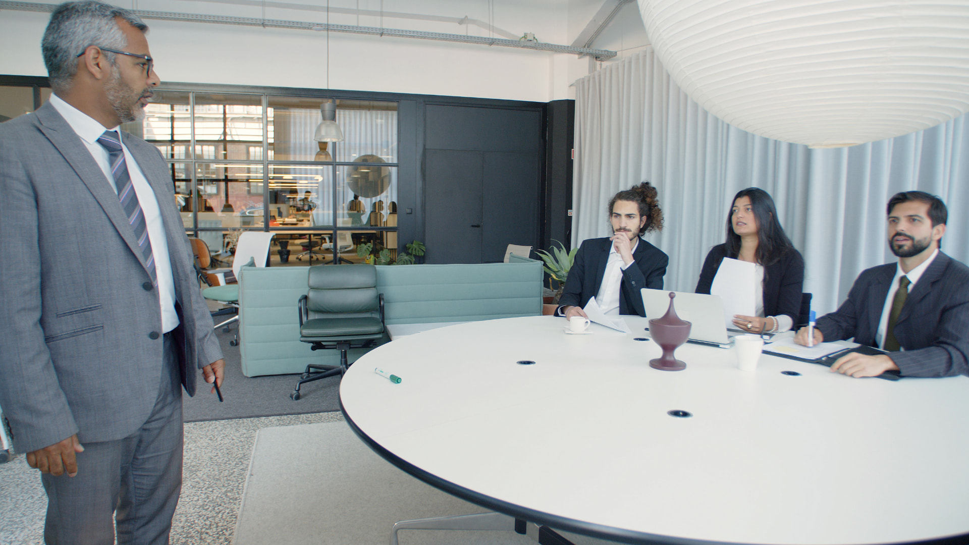 Facilitator presenting to a team seated around a boardroom table